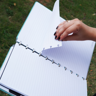 Pessoa movimentando uma página de seu caderno inteligente.